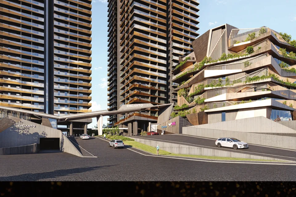 Encanto towers and the eight-storey clubhouse seen from the arrival road in Puppalaguda